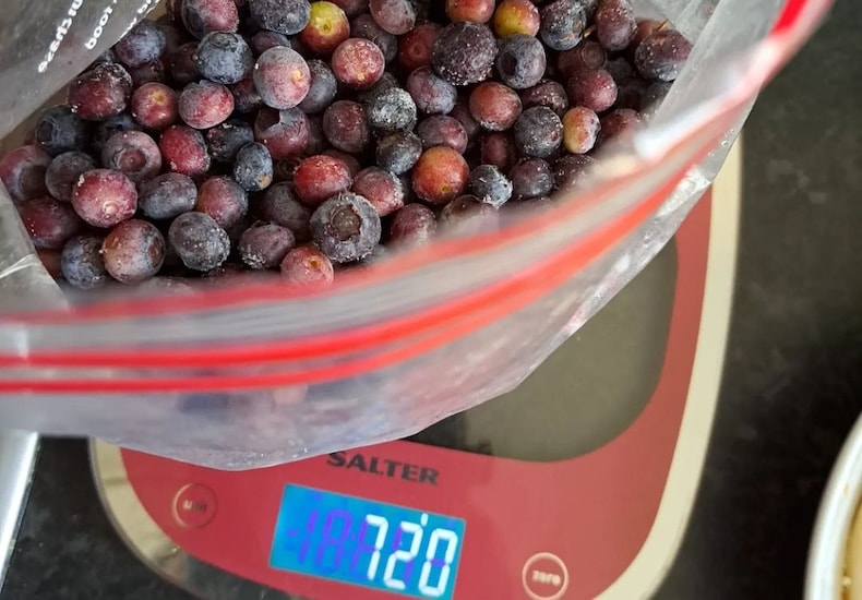 Weighing frozen blueberries in bag